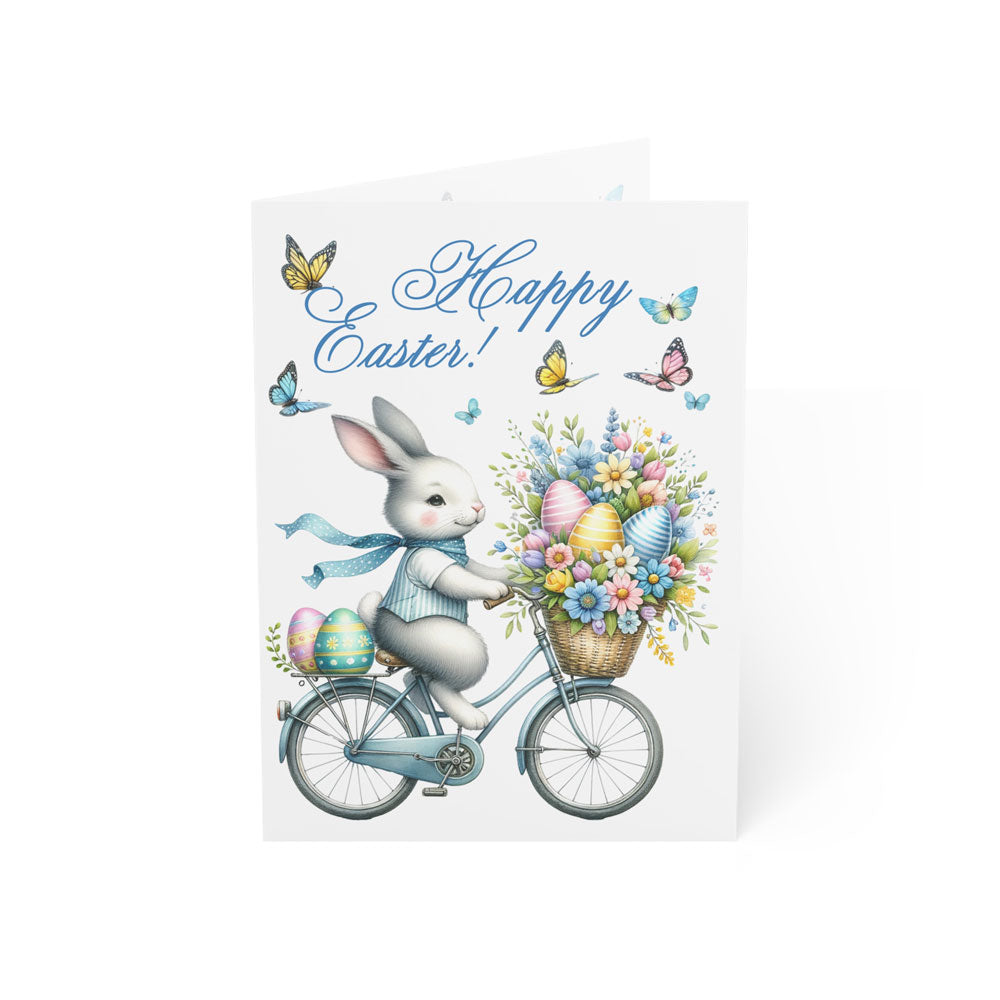 Easter Bunny greeting card with a cute bunny on a bicycle, carrying a basket of Easter eggs and flowers. Charming holiday card with Happy Easter text.