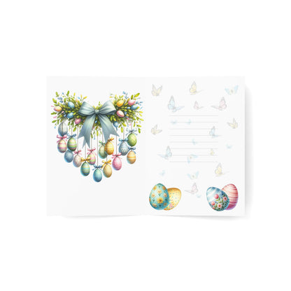 Inside view of an Easter greeting card with a pastel wreath of Easter eggs, soft butterfly accents, and space for a personalized message.